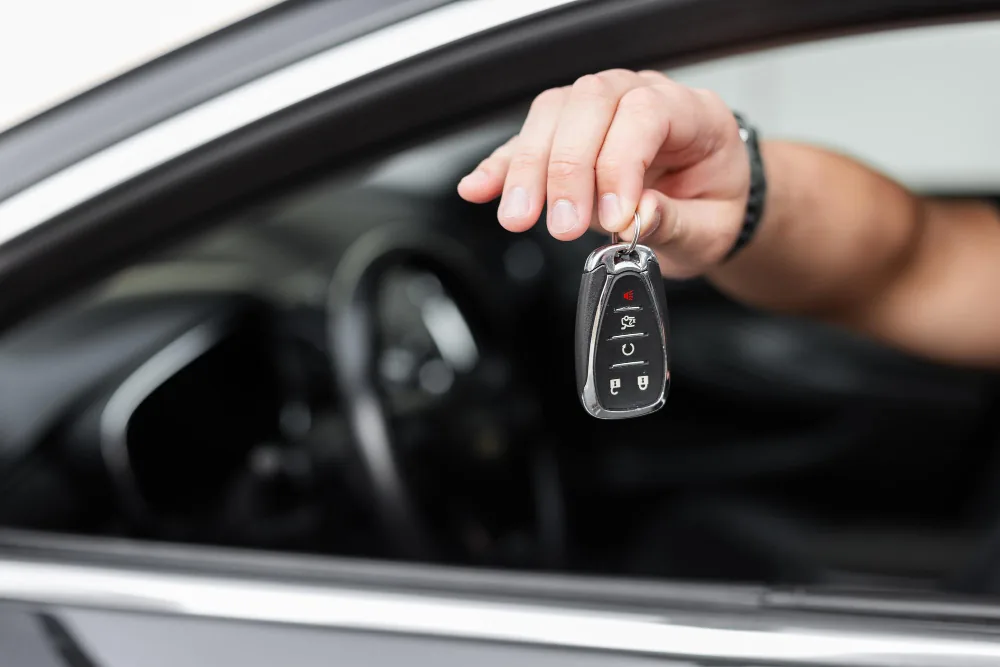 Rental agent handing over car keys through the window in the Bahamas